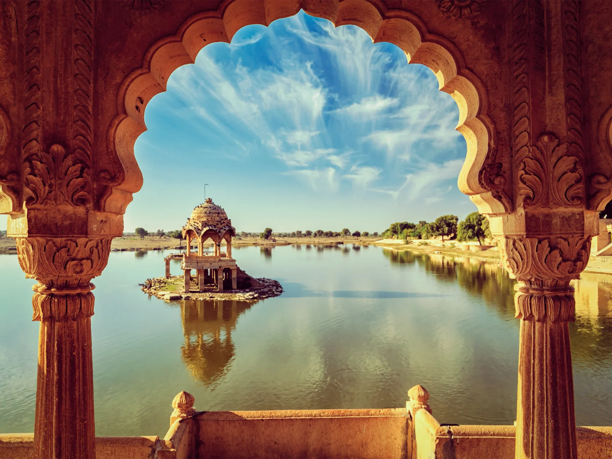Gadisar Lake framed by an ornate stone archway
